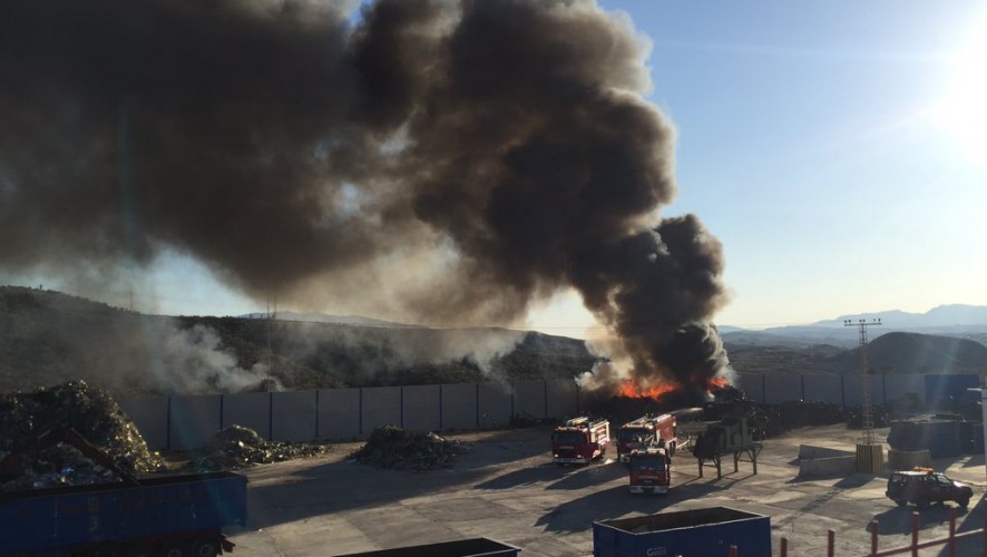 Bomberos trabajan en el incendio del solar de una nave de chatarra en Molina
